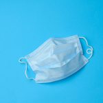 Blue disposable medical mask on a blue background
